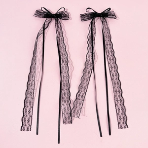 Détail de barrettes en dentelle noire avec longs rubans de style gothique et lolita