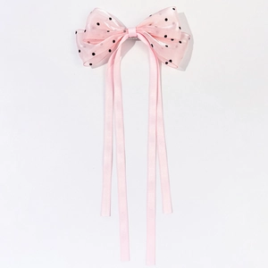 Détail du nœud rose à pois avec de longs rubans en satin élégants pour les cheveux