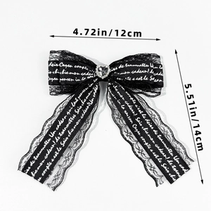 Detail of black lace bow hair clip with heart rhinestone and 12cm x 14cm size markings