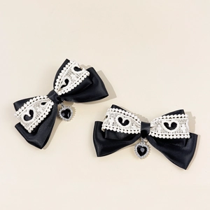 Detail of black satin bow hair clips with white lace heart trim and crystal pendant