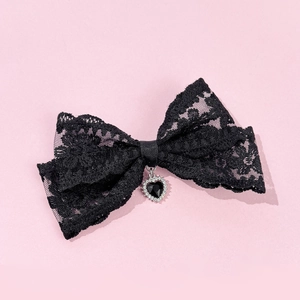 Close-up of black lace bow hair clip with a heart-shaped diamond pendant for women