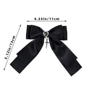 Detailed macro view of black gothic bow hairclip with heart gem and cross pendant