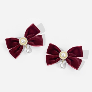 Detail of wine red velvet bow hair clips with faux pearl accents and teardrop pendant