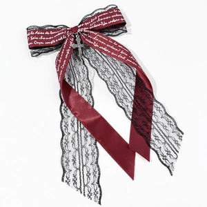 Detail of burgundy satin bow with black lace and silver cross pendant for gothic hair clips