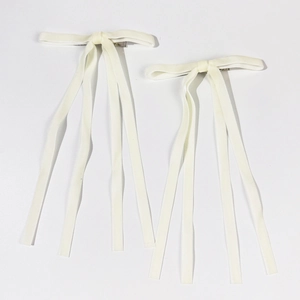 Detail of cream white velvet bow hair clips with long ribbons and metal duckbill clips