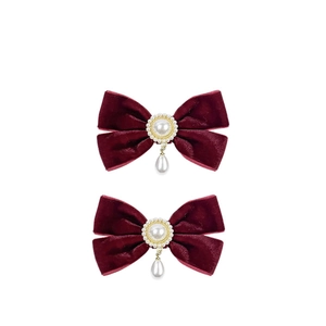 Elegant pair of wine red velvet bow hair clips with pearl pendants on white background