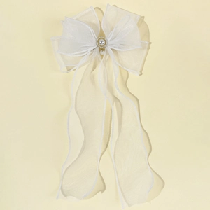 Elegant white organza bow hair clip with pearls and long tassels in a top-view shot
