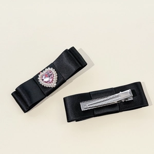 Barrette nœud en satin noir avec cœur en cristal rose et bordure en perles blanches