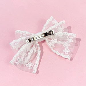 Large white lace bow hair clip with silver metal barrette clip on pink background
