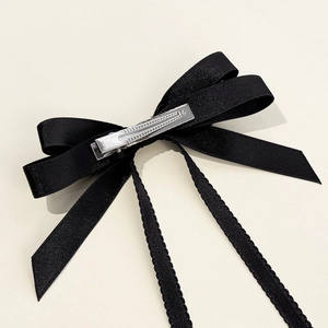 Elegant black satin bow hair clip with layered ribbons and wavy lace edges for women