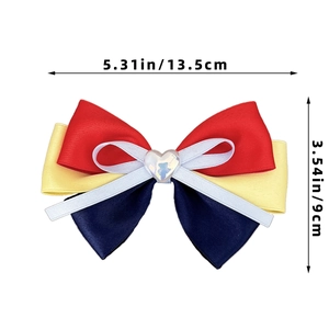 Detail of multi-layer bow hair clip with red, yellow, and blue ribbons and heart decor