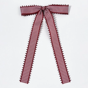 Detail of red and white checkered bow hair clip with elegant long fabric tassels