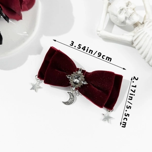 Detail of red velvet bow hair clip with vintage metal star and moon pendant decorations