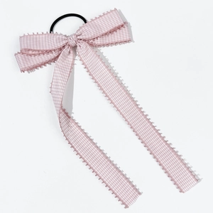 Detail of pink and white plaid bow hair tie with scalloped lace edges and long ribbons