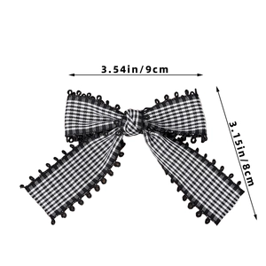 Detailansicht einer schwarz-weißen Schleife mit Spitze, Abmessungen von 9 cm mal 8 cm
