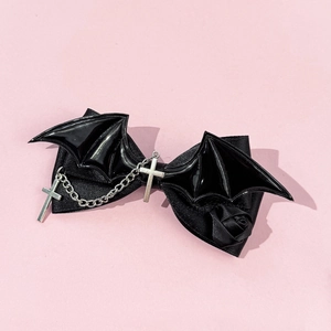 Detail of gothic bow hair clip with bat wings, silver metal chain, and a black rose
