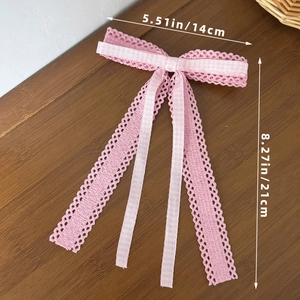 Détail d'un nœud en dentelle rose avec rubans à carreaux, taille 14cm sur 21cm