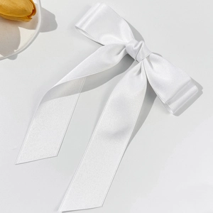 Détail de la barrette à nœud en satin blanc élégant avec texture ruban soyeux