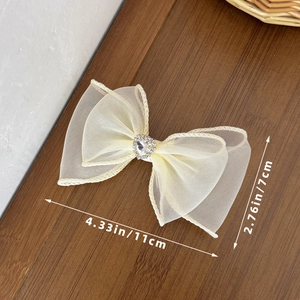 Détail d'un nœud en résille avec strass en cœur montrant les dimensions de 11cm de long