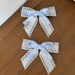 Détail du ruban à carreaux bleu clair et nœuds en dentelle grise en couches de tissu