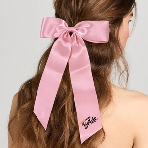Elegant pink satin bow hair clip with long ribbons and Team Bride print for wedding parties