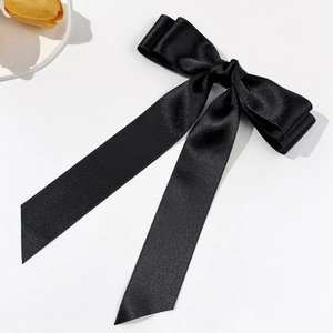 Détail d'un élégant nœud en satin noir avec de longs rubans et une texture soyeuse