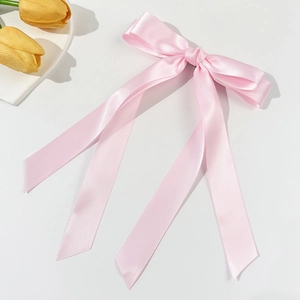 Nahaufnahme der eleganten rosa Satinschleife Haarspange mit langen Bändern und Seidenglanz