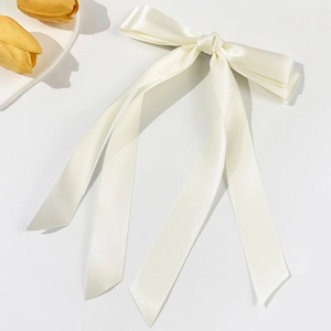 Detail einer cremeweißen Satin-Doppelschleife mit eleganten, fließenden Bändern