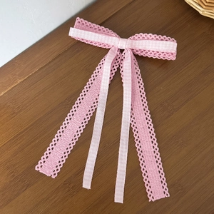 Détail du nœud rose en dentelle et à carreaux avec rubans sur une table en bois