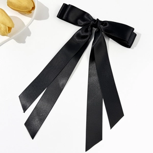 Nahaufnahme der eleganten doppellagigen schwarzen Satin-Schleife mit langen Quasten