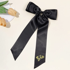 Detail of black satin bow hair clip with yellow Team Bride print and crown pattern