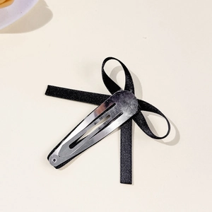 Süße schwarze Haarschleife im koreanischen Stil mit silbernem BB-Clip auf hellem Grund
