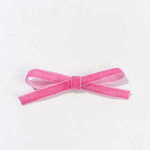 Gros plan d'un nœud papillon en velours rose avec texture douce et détails de couture