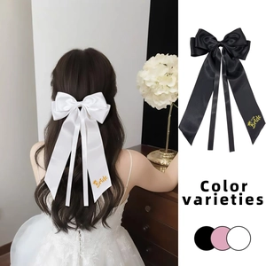 Detail of elegant satin bow hair clips with Bride gold lettering for wedding hair styling
