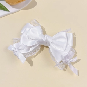 Detail of multi-layered white satin ribbon hair clip with lace trim in lolita style