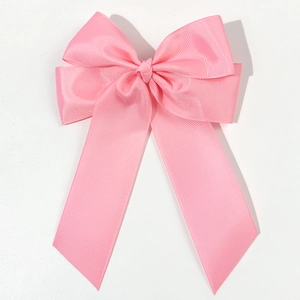 Fermaglio per capelli con fiocco in nastro grosgrain rosa su sfondo bianco