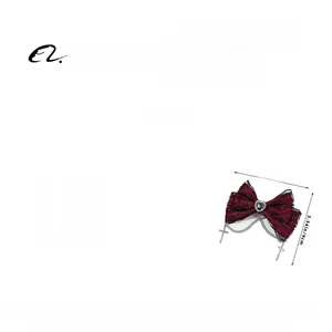 Detail view of dark red lace bow hair clip with black gem and cross metal chains