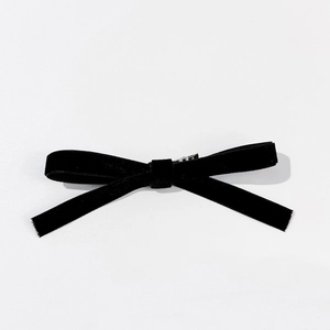 Vue détaillée montrant la texture en velours doux et le clip en métal du nœud noir