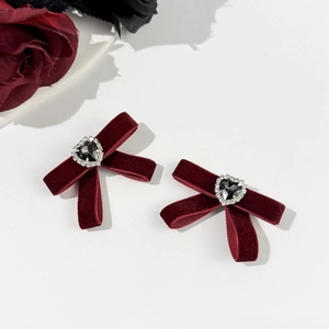 Detail of wine red velvet bow hair clips with heart-shaped black gemstone and small diamonds