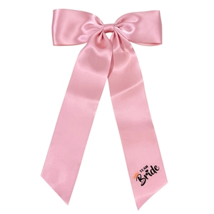 Pink satin bow hair clip with long streamers featuring Team Bride print for weddings