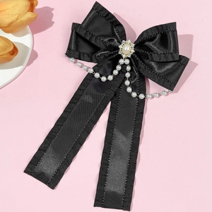 Detail einer schwarzen Lolita-Schleife mit Perlen und funkelnden Strass-Quasten