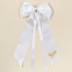 Elegant white satin bridal bow hair clip with gold Bride print and long ribbons