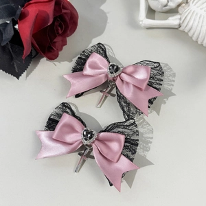 Detalle de horquillas góticas con raso rosa, encaje negro y colgante de cruz