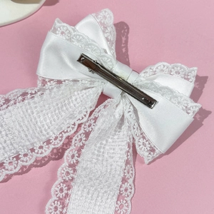 Elegant white lace bow hair clip with silver metal alligator grip on pink background