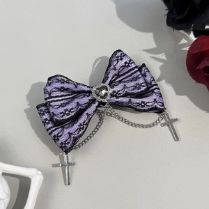 Macro shot of Gothic lace bow hair clip with heart gem and silver cross chains