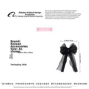 Macro shot of large black tulle bow hair clip with elegant long ribbon streamers