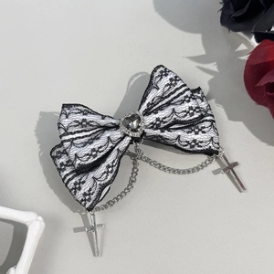 Detail of gothic lace bow hair clip featuring a heart gemstone and silver cross chains