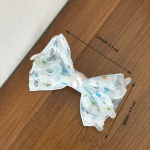 Détail pince à cheveux nœud en dentelle bleue florale avec perle centrale, 6,5 cm