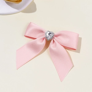 Pink satin bow hair clip with a sparkling rhinestone heart for sweet ballet style accessories