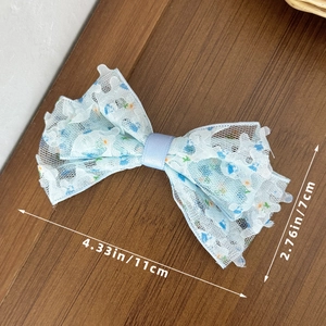 Détail d'une barrette à cheveux nœud en dentelle florale bleue de 11x7cm sur bois